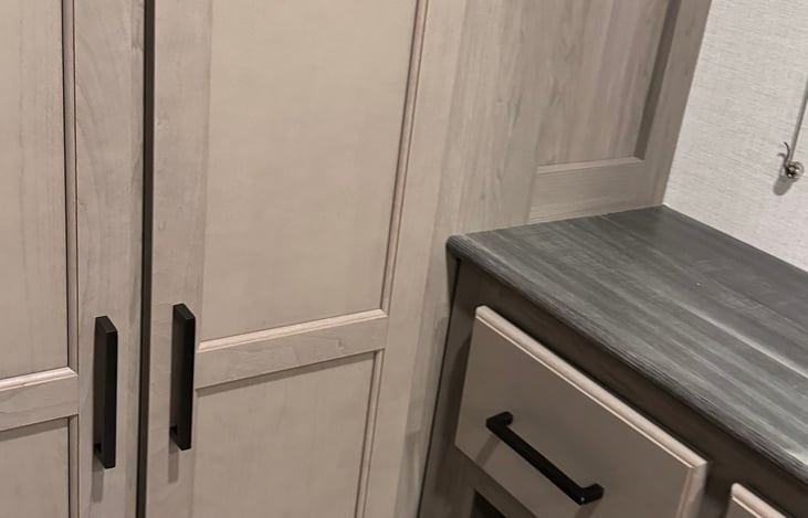 LEFT DOOR HAS 3 STORAGE SHELVES. RIGHT DOOR SPACIOUS WITH CLOTHERS HANGING ROD