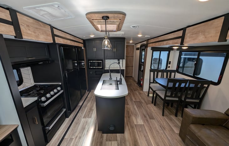 Very spacious kitchen with gas stove, oven, microwave, double-fridges, island with sky light, ample storage, and more.