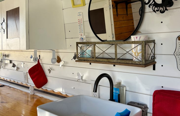 This is the sink with a completed vanity. Above the mirror there is a light.