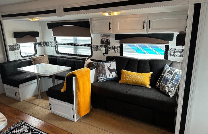 MAIN LIVING AREA THAT HAS CONVERTIBLE BOOTH WITH EPOXY AND CONVERTIBLE SOFA.