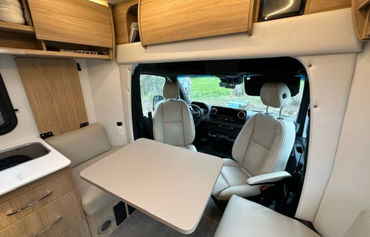 Front lounge with driver's and passenger's seat turned around to join dining/seating area.