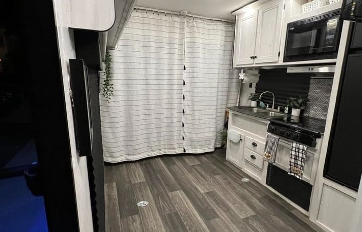 Main living area, bunk bed and couch behind curtains for privacy