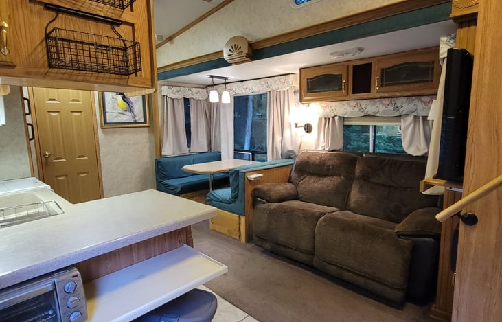 View as you walk in the door to the kitchen, dinette, and reclining love seat.  Rear bunkhouse is the door on the left, and stairs to the bathroom and primary bedroom is on the right.