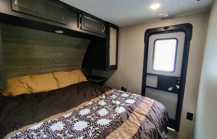 Master bedroom has a skylight and door to the outside.