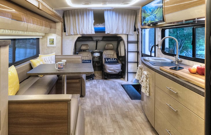 Interior towards front. The seats in the cab swivel to provide additional seating. Bed over cab behind curtains above