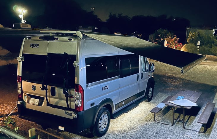 Electric awning with LED light. Van equipped with various outdoor puddle lights.