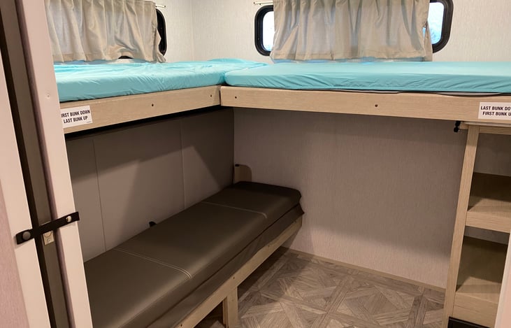 Bunk room with both bunks in the down position and the Versa Queen closed.