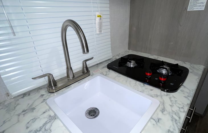 Kitchen sink, and 2 top propane stoves.