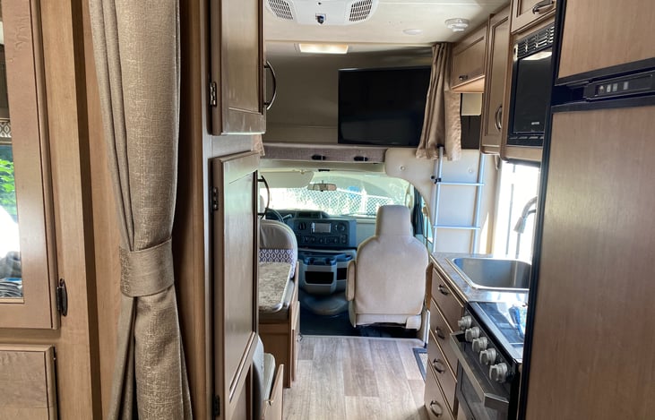 View to the front of the RV from the bed area.  Left is storage, right is fridge/freezer combo.