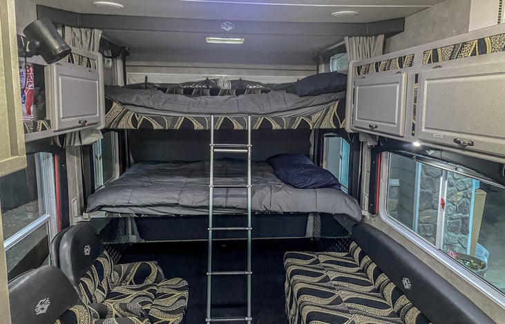 Rear Queen bunk beds, fold out couch or full size bed, two rocker chairs.