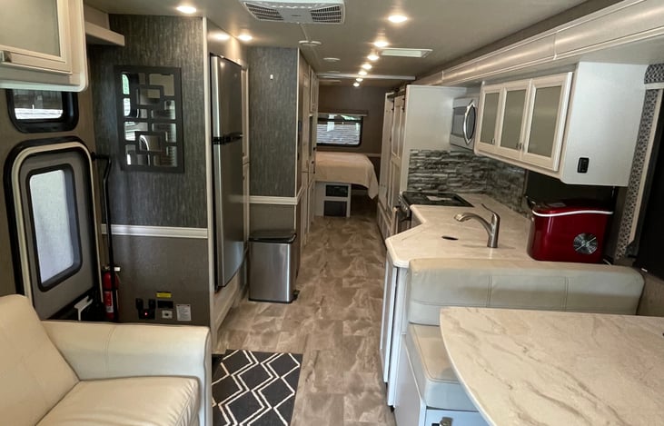 Cook your favorite meals on the road with a fully equipped kitchen featuring generous counter space, a large refrigerator, and plenty of storage