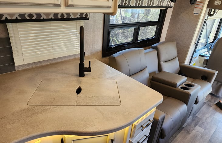 Covered sink that extends kitchen area countertop working surface for food preparation and placement. There's also a pop-up USB charging station built into the counter area for charging phones, etc.