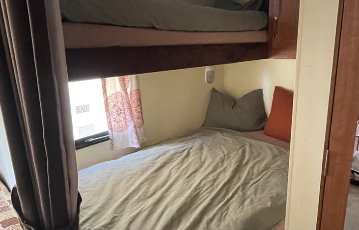 Bunk beds in back corner. All our bedding is organic cotton or at least OEKO tex certified.
- top bunk will sleep a child or small adult
- bottom bunk (twin) will fit two children or one adult