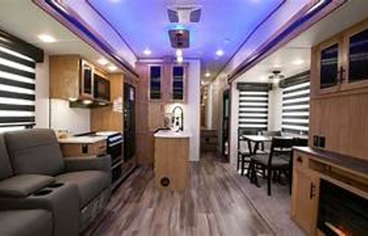 The spacious open floor plan with opposing slide-outs mimic the feel of a modern home rather than a traditional RV. Kitchen and living areas are seamlessly connected.