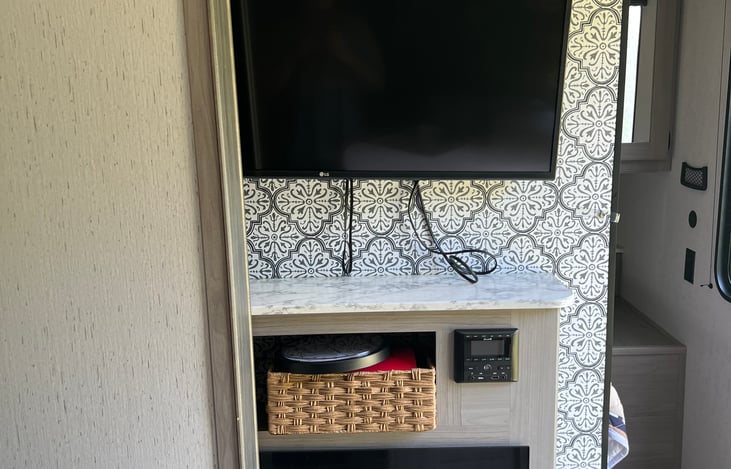 Newly hung tv, must pull string to release and swivel towards couch. Electric fireplace for cold days in the RV the temp can be adjusted by touch screen.