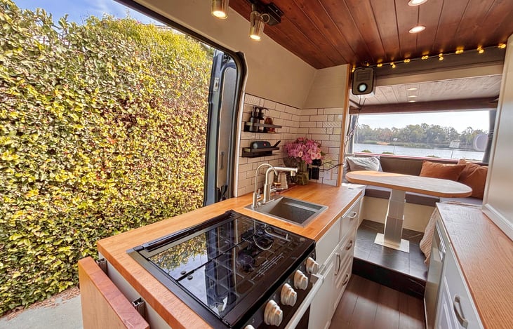 Fully stocked kitchen: sink, gas stove, oven, microwave, and refrigerator