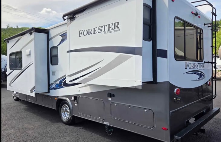 Exterior view showing the RV’s slide-outs fully extended. These expand the interior living space when parked, providing guests with extra room to relax, dine, and move around comfortably during their