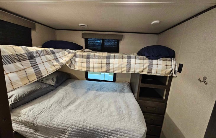 Rear room bunk bed that sleeps 4 comfortably. Top 2 beds are twin sized while the bottom bed is a full-sized bed. bedding and pillows included.