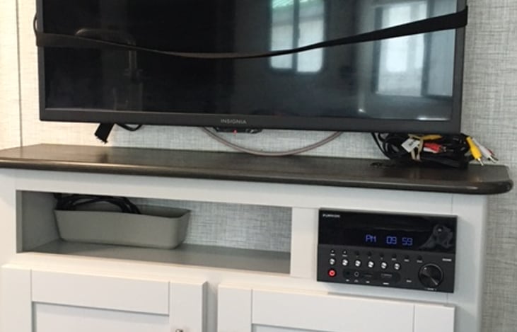 The large TV has a DVD player, AM/FM radio and is Bluetooth compatible. The cabinet below has movies, books, and small games for both kids and adults.