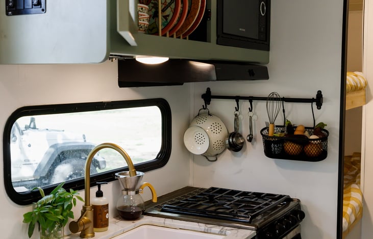 Fully operational kitchen with sink, microwave, oven, and cooktop. Pantry stocked with spices, coffee, tea, and cooking oil.