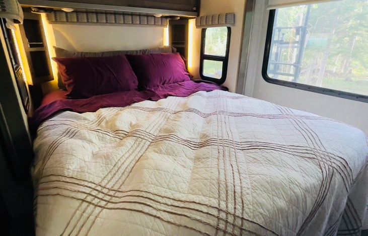 Slide-out queen size bedroom with TV.