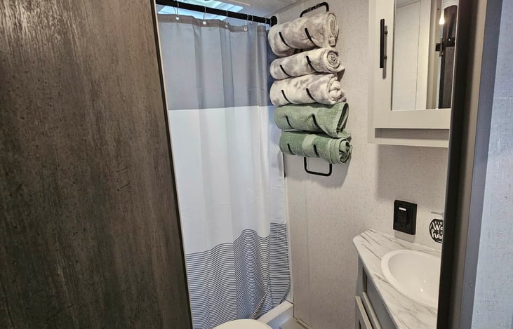 Bathroom - Shower behind the curtain, not a tub. Hand towel, TP, first aid kit in upper cabinet.