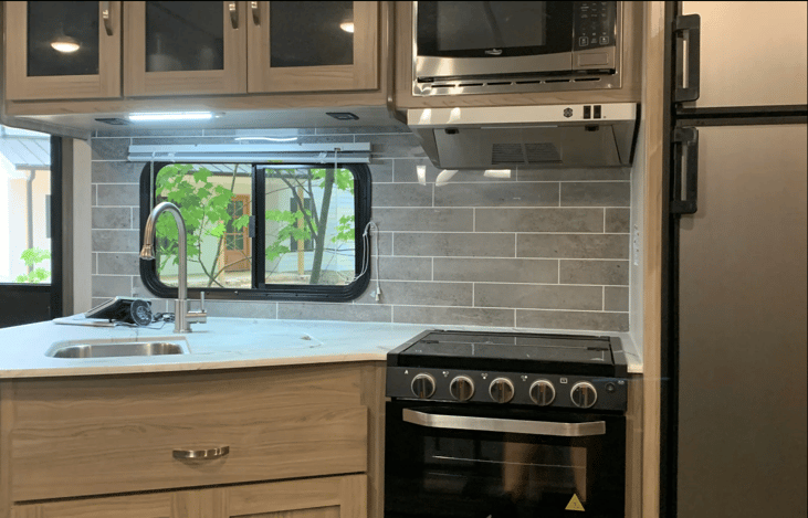 Kitchen with stove, double sink, microwave and freezer/fridge