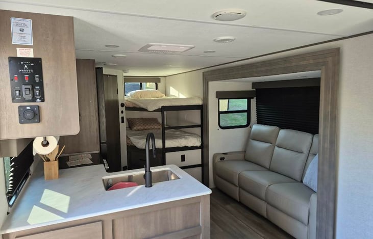 Modern luxury inside! Features a private master queen, double bunks, a huge U-shaped dinette slide-out, a fully loaded kitchen, a 10.2 cu ft fridge, a full bath, and premium JBL sound.