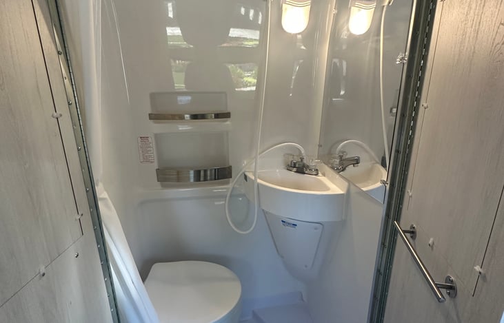 Bathroom with toilet, sink, and shower (two rolls of RV toilet paper included)