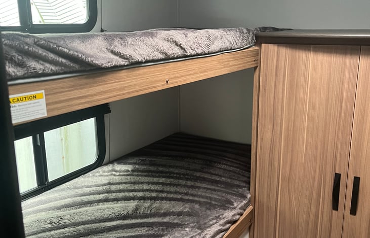 Bottom left bunk has a baby gate that’s easy to move up and down (not pictured here) for the safety of little ones!