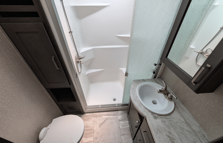 Spacious bathroom with full walk-in shower and skylight for natural light.