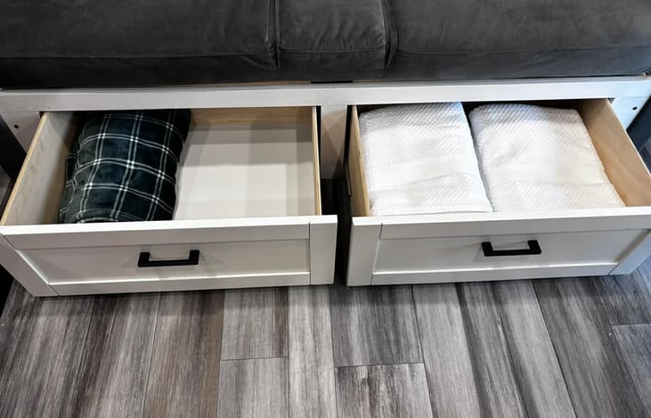 A clean, organized storage bench showcasing fresh towels and a cozy blanket, giving renters practical comfort and easy access to essentials.