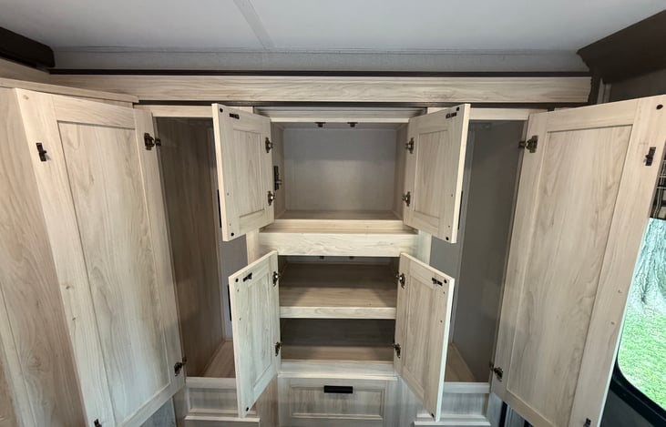 Armoire with the doors open. Each side has the ability to hang clothes. The top middle has a 12V cigarette plug to plug an inverter, TV or whatever you wish ... except a cigarette.