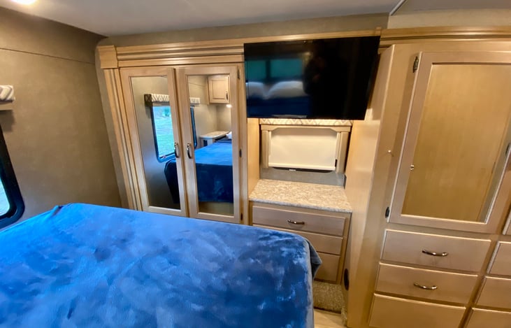 From the head of the bed facing the closet space and television