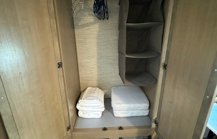 Roomy closet, with added hanging organizer. Set of towels included.