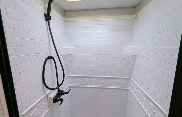 Spacious bathroom with shower and toilet.