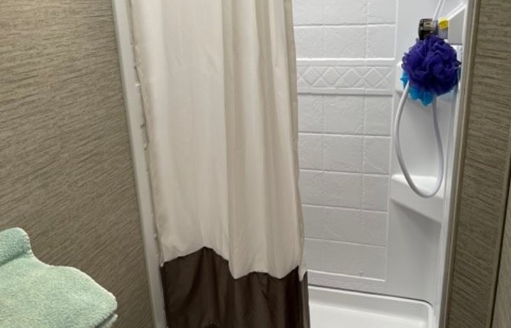 Full size shower, separate toilet and sink with vanity storage