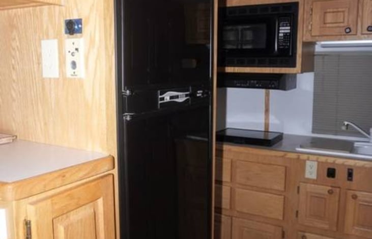 black refrigerator and kitchen area