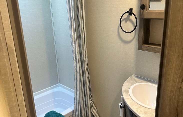 skylight, overhead lights, and fan in bathroom