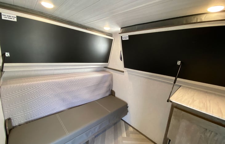 Back room has a door that closes for privacy,  there are 2 single bunks on top and a full size bed on the bottom, they fold up for extra room during the day for the kids.  Perfect space for your guest