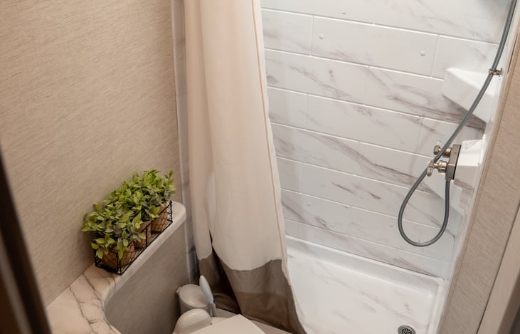 full sized stand up shower and porcelain toilet