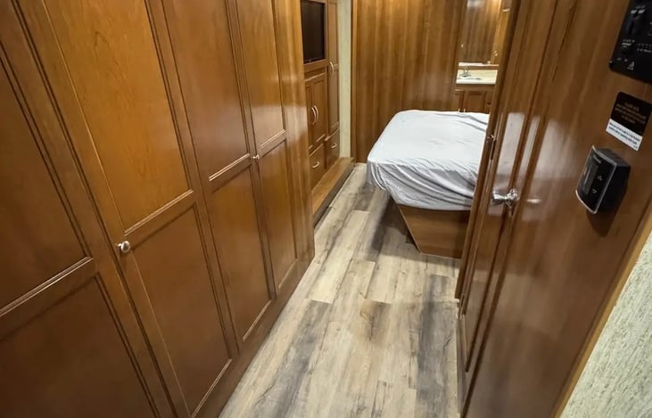 Hall with bunks behind magnetic doors on left, half bath access on right and straight through to master bedroom and full bath in back.