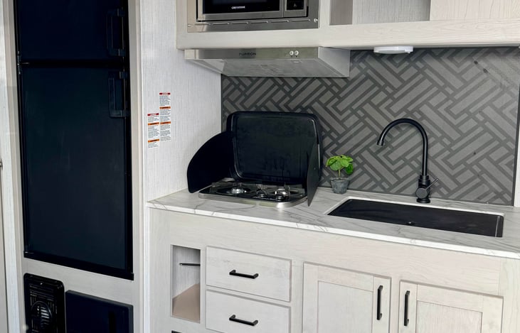 Kitchen area. Pots, pans, silverware, and cooking accessories are all included.