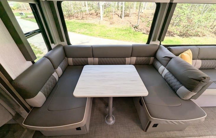 Bright and modern interior with a Custom King bed, double bunks, and a Versa-Lounge slide. Features a 30” fireplace, panoramic windows, 10.7 cu ft fridge, and a walk-in closet. Luxury camping at its f