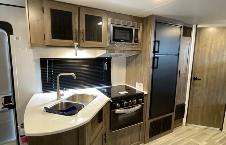 Kitchenette, including cold/hot water, microwave, gas range and stove, electric/gas refrigerator and freezer