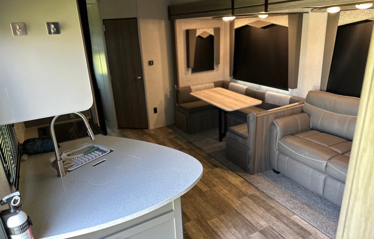 Entryway with kitchen counter, nice pullout, couch and seating for six.