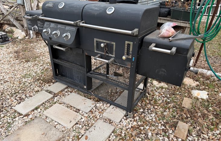 Outdoor gas grill with sear burner.  The other side is a woodchip smoker.  Starter bag of wood chips available.