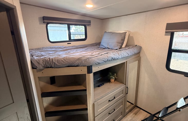 Bunkhouse full size bunk with bookshelf ladder, entertainment, dresser drawers and closet.