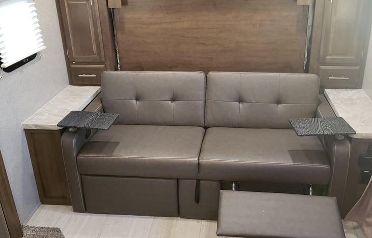 Couch with 2 foot rests & side tables.