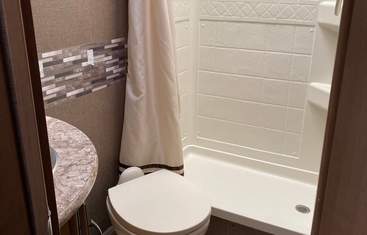 Sink, toilet and good-sized shower in the bathroom.